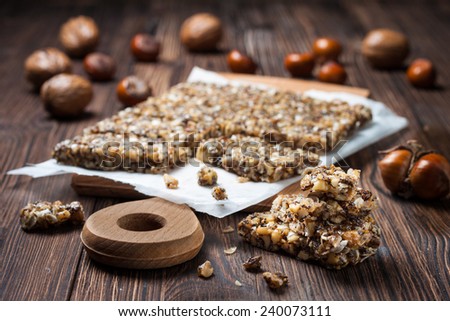 energy bar with hazelnuts, walnuts, poppy seeds and honey on a wooden board in a rustic style