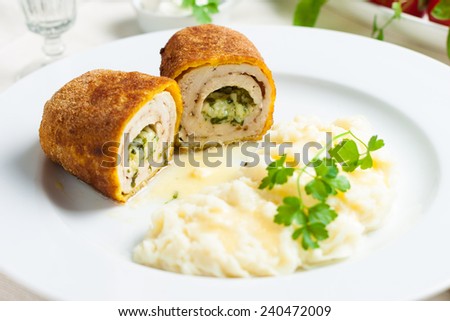 chicken and chicken Kiev with mashed potatoes. Chop chicken fillet stuffed with juicy butter, cheese and greens on a white plate
