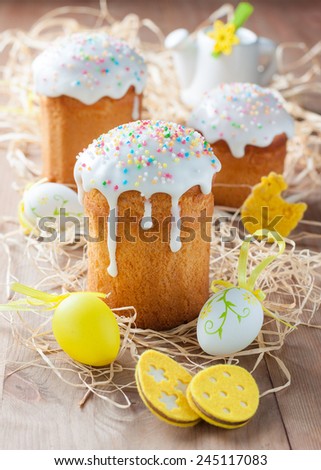 Easter cakes and colored eggs on a light wooden background