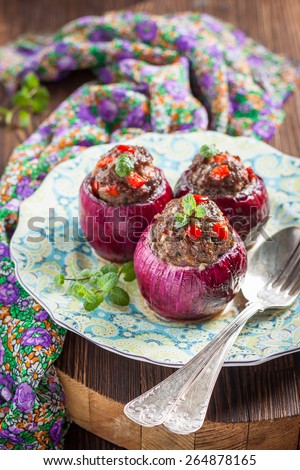 Red onion stuffed lamb with mint and paprika on a dark wooden background