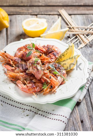 skewers of shrimp wrapped in bacon with lemon