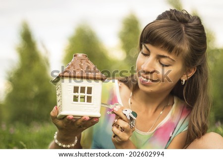 Beautiful young girl holding in hands beautiful house and open it by her hands