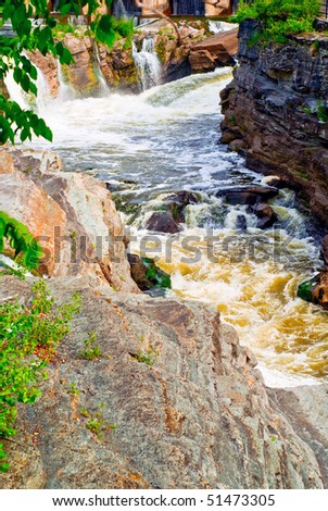 A violent, gushing rapids cut through a geological formation known as a 