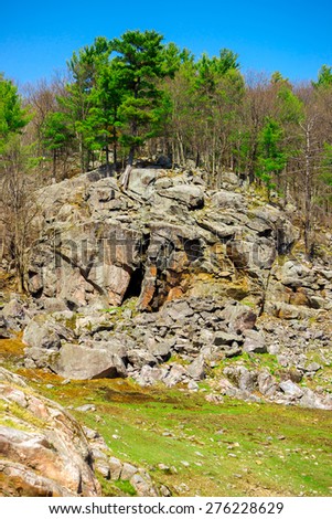 Landscape image of a very large tree covered rocky cliff in the heart of the Canadian shield.