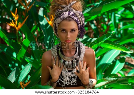 Attractive young caucasian woman in turban with jungle background