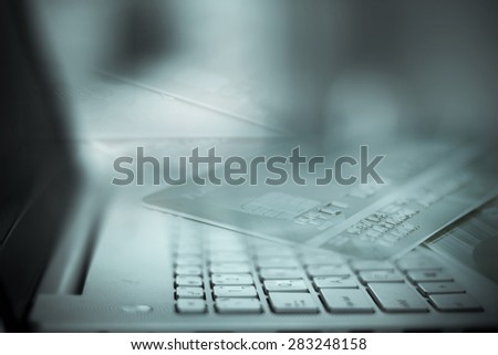 Vintage tone of Close up selective focus of the silver laptop computer with filtered by part of credit card