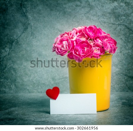vintage and retro color tone of the Fresh pink carnation flower and blank card for copy space over stone plate background