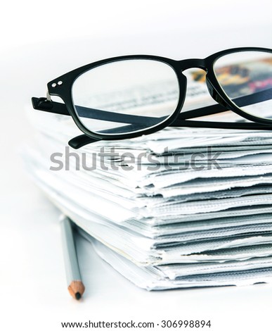 the reading eyeglasses with stacking of newspaper background ,  business information concept