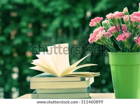 the fresh pink carnation flower with books
