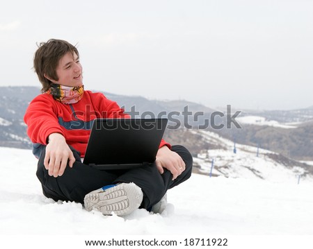 Happy teens student with laptop in winter mountains Tien Shan