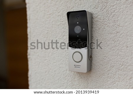 doorbell on the wall of the house with a surveillance camera