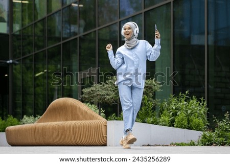 Similar – Image, Stock Photo Young Arab woman walking in the street using her smartphone