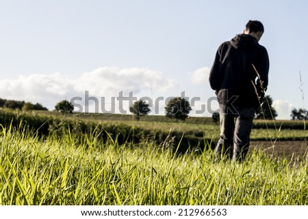 green grass in the countryside and man walking in the back