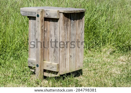 outdoors recycled wood garbage container in a public green area