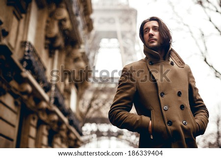 Man posing in coat on Eiffel tower background