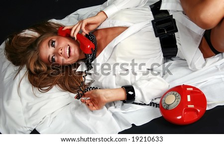 Pretty girl talking by red vintage phone.