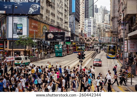 HONG KONG, CHINA - MAY 22, 2014: Group of busy people crossing the street and waiting for trams on May 22, 2014 in Hong Kong, China