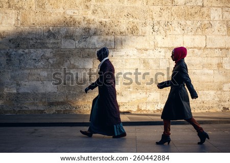 ISTANBUL, TURKEY - NOVEMBER 28: Women walking on background of old wall in Istanbul, Turkey on November 28, 2014