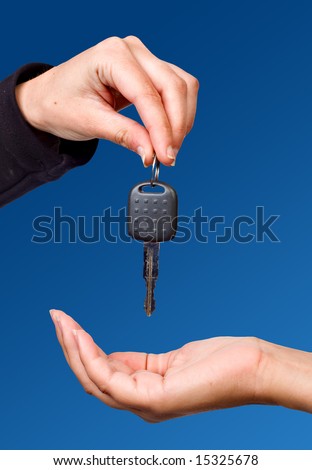 Hand giving a key over blue sky
