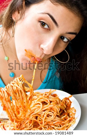 Young girl enjoying a bowl of pasta with tomato sauce