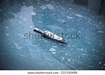 Wine bottle abandoned in a river of polluted water - alcoholism concept image