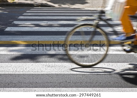Bicycle riders on pedestrian crossing in motion blur with copy space