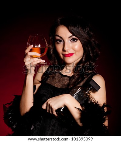 Vintage woman in retro dress with cognac on dark background. Pin-up girl