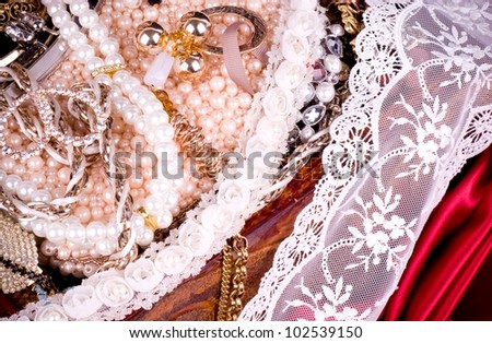 Vintage laces with jewelry on wooden background