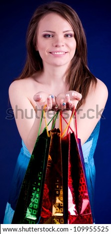 Beautiful young woman holding shopping bags and smiling