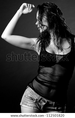 Beautiful young woman in wet shirt on dark background
