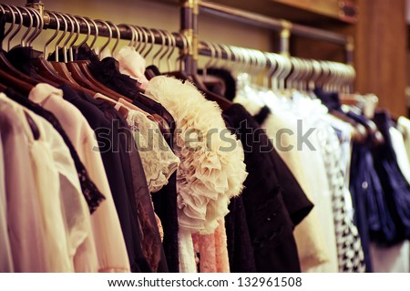 Choice of fashion clothes of different colors on wooden hangers