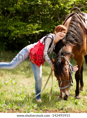 Young smiling woman with horse in the forest