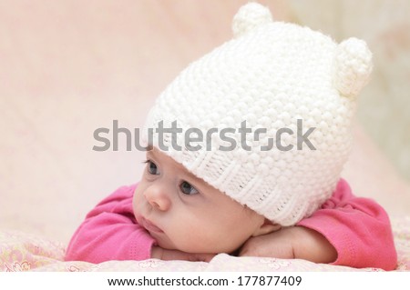 Charming child. Little girl in white knitted bear hat