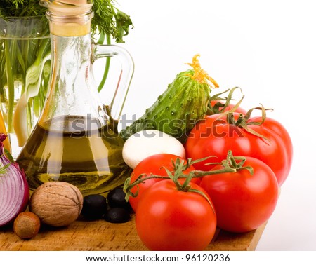 Olive oil and tomatoes and other vegetables on a white background