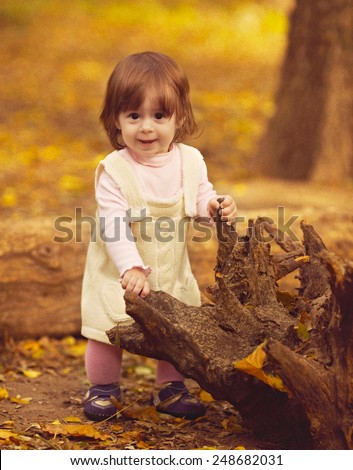 Funny little girl in autumn forest