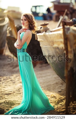 Fashion brunette girl alongside wooden boat