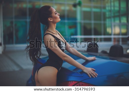 Beautiful young woman in fashion clothes in blue car