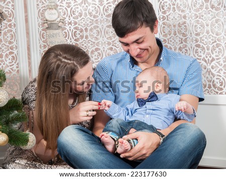 Beautiful family with a baby near Christmas tree. Family Portrait