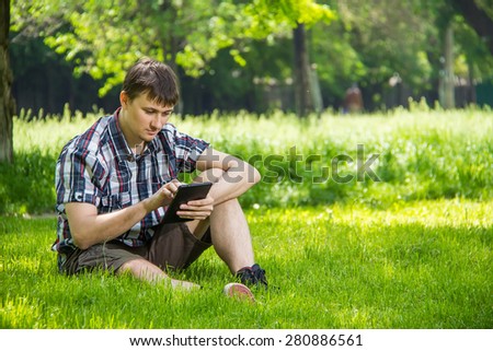Student studying in the park sitting on the grass