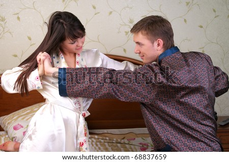 Young couple have a fun fight in bedroom