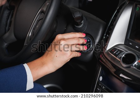 beautiful young woman at the wheel of a modern car