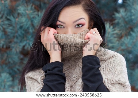 beautiful happy young woman was wearing a high neck sweater, in the forest in winter
