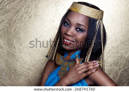 beautiful dark-skinned girl black woman in the image of the Egyptian queen with red lips bright makeup demonstrates long nails