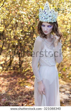 beautiful lovely gentle graceful fairy fairy in a flower crown and light dress walks through the woods on a sunny day early