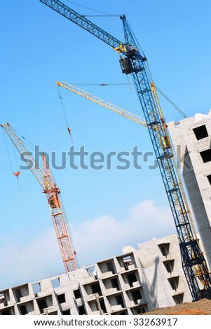 Building crane and building house against the blue sky. Building site