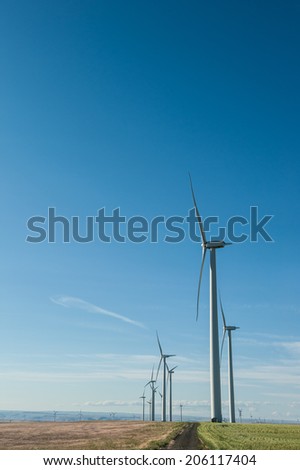 Sustainable wind energy generators against blue sky; renewable energy that helps fight against global warming