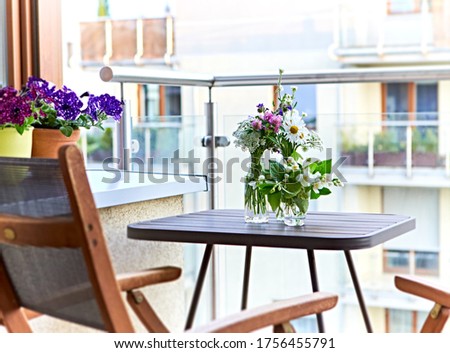 Bouquets of meadow flowers in glass bottles on balkony. Relax zone at home Zdjęcia stock © 