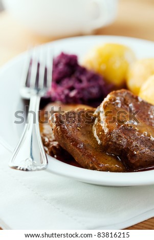 Roast beef with potato dumpling and red cabbage. German cuisine