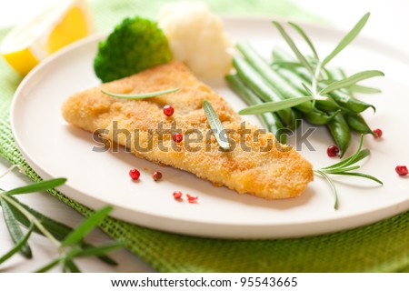 Breaded fish fillet with vegetables and rosemary