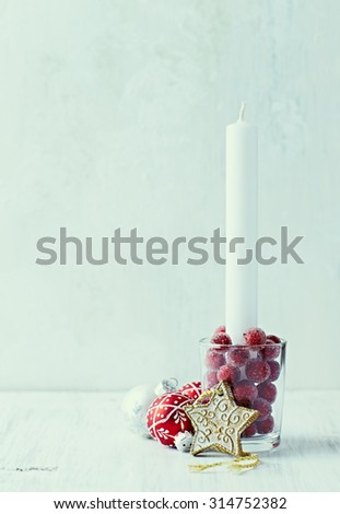 White candle and vintage Christmas decorations